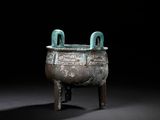 an old bronze pot with two handles on a wooden stand