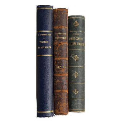trois vieux livres posés l'un sur l'autre sur une surface blanche