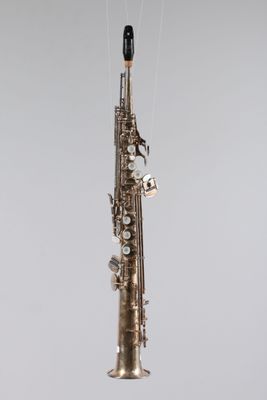 une image représentant un saxophone suspendu à une ficelle accrochée au mur