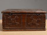 an old wooden box with carvings on it sitting on top of a table