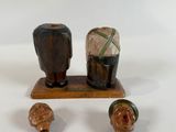 three figurines on a wooden stand on a white surface