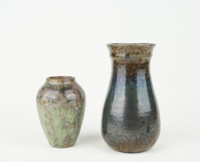two vases sitting next to each other on a white surface