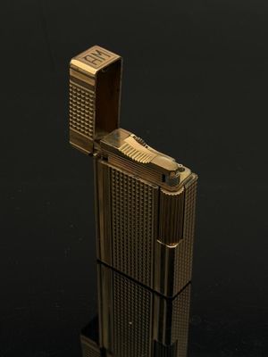 un briquet doré posé sur une surface noire