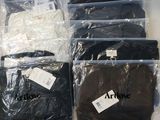 many bags of clothing that are sitting on a table