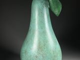 a close up of a green pear with a leaf on it