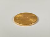 an image of a gold coin sitting on top of a white surface