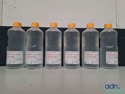 Quatre bouteilles de liquide sont alignées sur une table