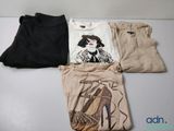 trois paires de t-shirts et un pantalon posés sur une table