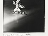 Photographie en noir et blanc d'un homme descendant une rue en skateboard