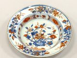 une assiette bleue et orange décorée de fleurs