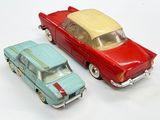 two toy cars sitting next to each other on a white surface