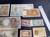 several different bank notes are displayed on a black surface