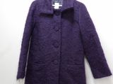 purple coat hanging on a hanger on a white wall