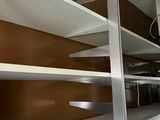a room with a lot of shelves and a tv on the wall