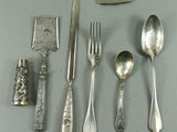 de nombreuses cuillères, fourchettes et un couteau en argent posés sur une table