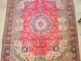 a red and blue rug with a medallion design on it