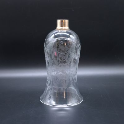 a clear glass bottle with a gold lid on a table