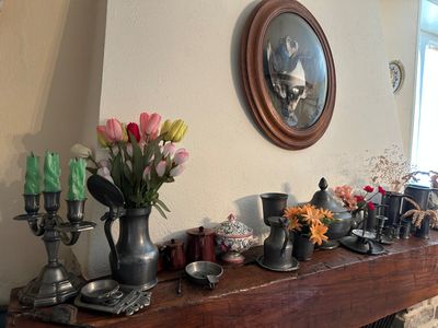 de nombreux vases posés sur la cheminée, remplis de fleurs