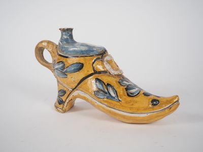 a yellow and blue shoe shaped vase with a bird on it