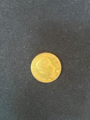 a close up of a gold coin on a black cloth
