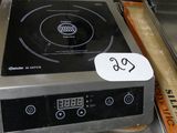 un plan de travail en acier inoxydable équipé d'une cuisinière électrique et d'un plateau de beignets