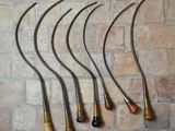 six pipes à fumer antiques alignées contre un mur de briques