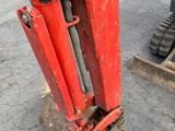 a red excavator that is sitting on the ground