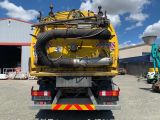 a large yellow truck that has a hose on the back of it