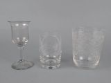 three glasswares and a wine glass on a gray surface