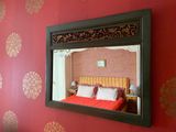 un miroir accroché au mur au-dessus d'un lit dans une chambre