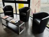 deux chaises noires et une table basse dans une pièce