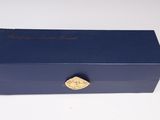 a blue box with a gold emblem on it sitting on a white surface