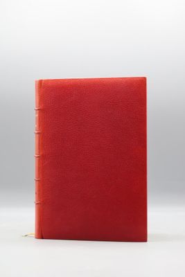 un livre rouge posé sur une surface blanche