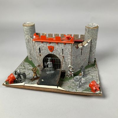 un château miniature au toit rouge posé sur un fond blanc