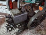 un petit moteur posé par terre à côté d'un tracteur