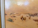 un tableau représentant un homme chevauchant un chameau dans le désert