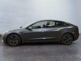 the tesla model 3 is parked in a studio with a gray background