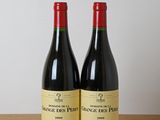 deux bouteilles de vin rouge posées sur une table en bois