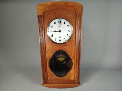 une horloge en bois avec un cadran noir sur fond blanc