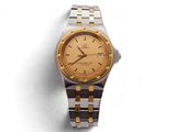 une image d'une montre-bracelet en or et argent sur une surface blanche
