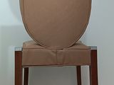 a brown chair with a round back and a wooden frame