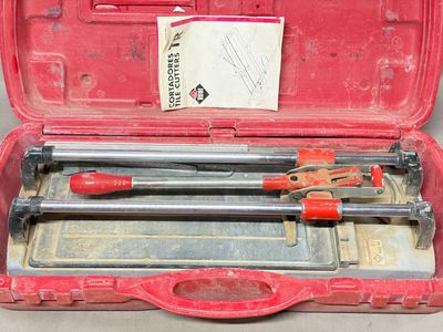 une mallette rouge contenant des outils, posée sur une table