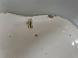 a white porcelain bowl with holes in it on a table