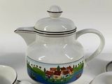 three cups and a teapot sitting on a table