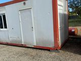 a small white and red container sitting in the dirt