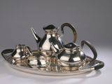 a silver tea set on a silver tray on a table