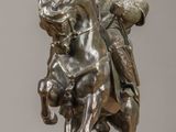 bronze statue of a man on a horse with a bird on his back