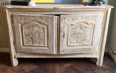 une armoire blanche ornée de sculptures, placée dans un coin de la pièce
