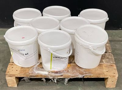 plusieurs seaux de peinture blanche posés sur une palette en bois