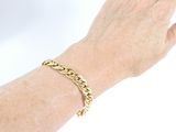 someone is wearing a gold bracelet with a chain on their wrist